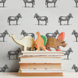 illustrated black donkey on white background wallpaper pattern behind stack of books peel and stick