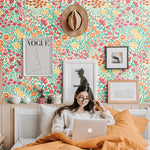 orange yellow pink and teal meadow design pattern on peach colored background Removable Peel and Stick Wallpaper in bedroom
